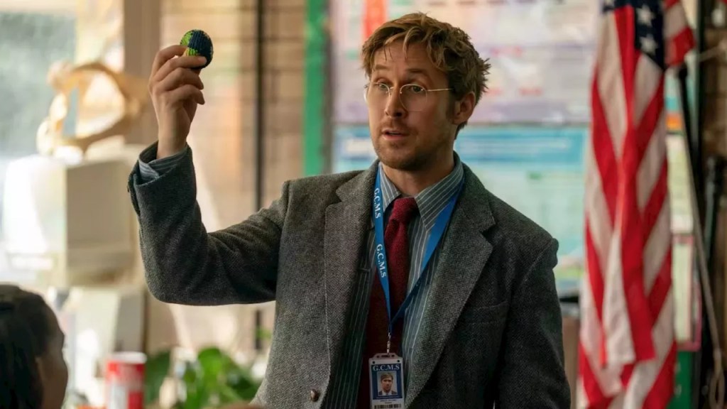 A man with dirty blonde hair and glasses teaches a class.